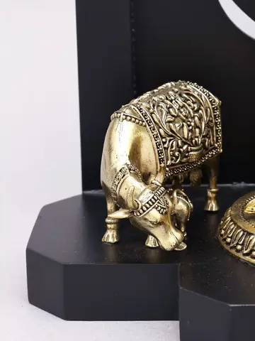 The brass cow on the wood base
