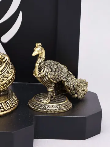 The brass peacock on the wood base