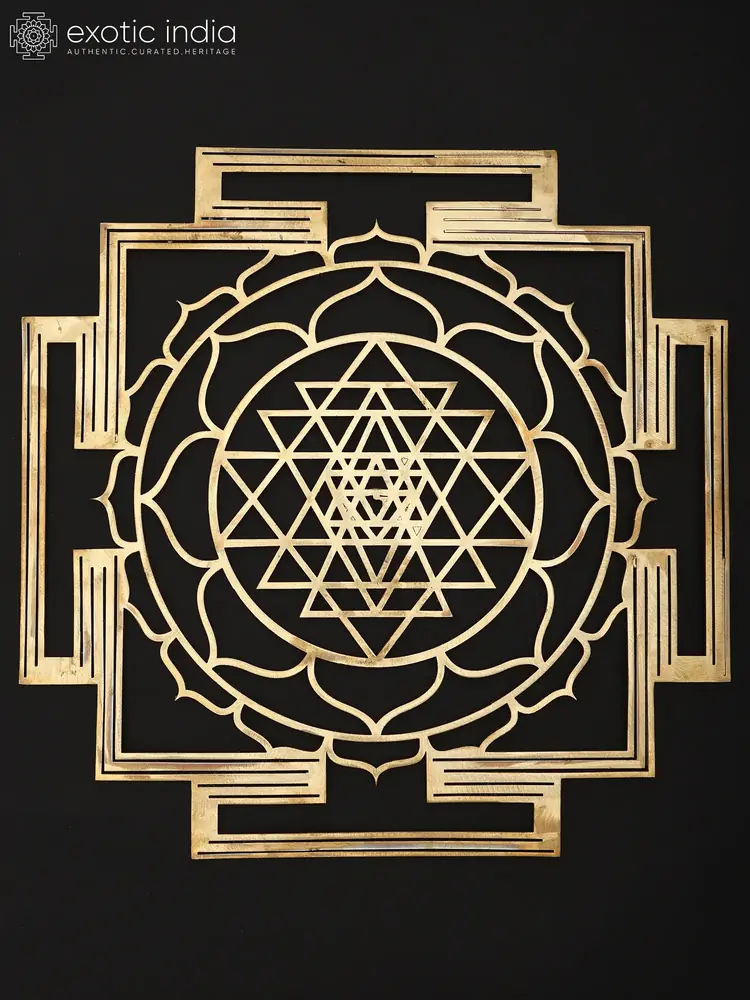 Brass Shri Yantra wall hanging seen whole on a dark ground