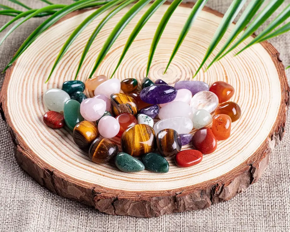 Mixed tumbled stones piled on a wooden slice