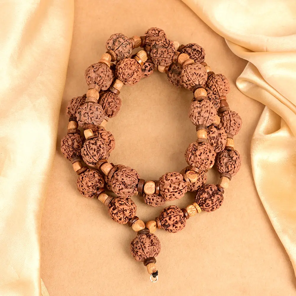 Rudraksha mala with wooden spacer beads looped on cream cloth