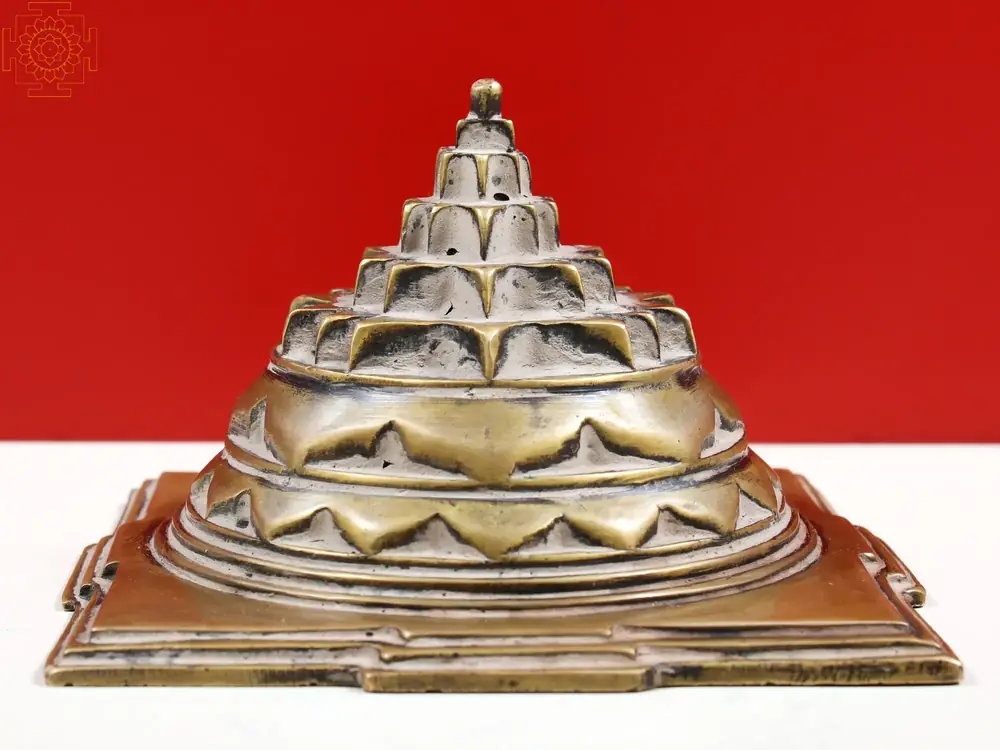 Stepped brass Shri Yantra seen from the side on red