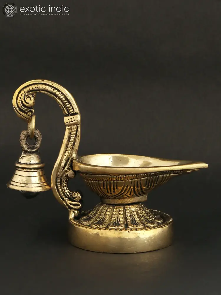 Brass handheld lamp with bell, front view on a dark ground