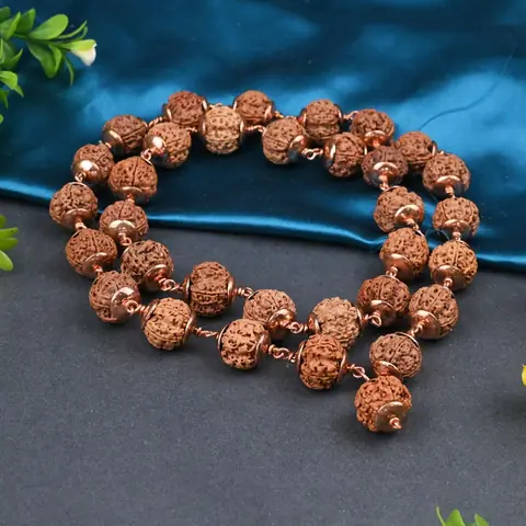 The mala coiled on a grey and blue ground