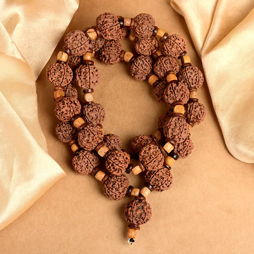 Rudraksha mala with wooden spacer discs looped on cream cloth