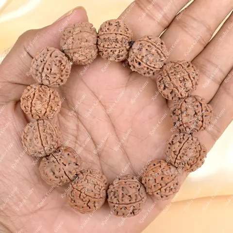 The bracelet held in an open palm for scale