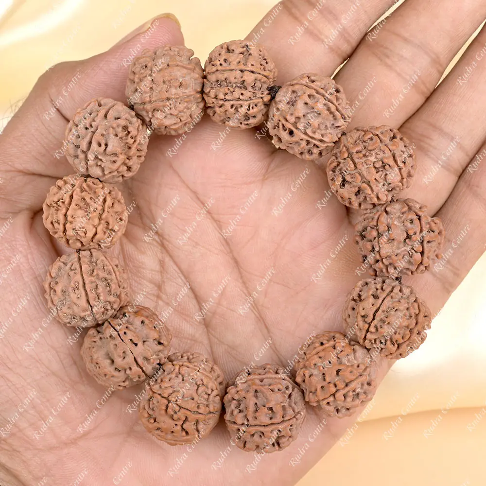 The bracelet held in an open palm for scale