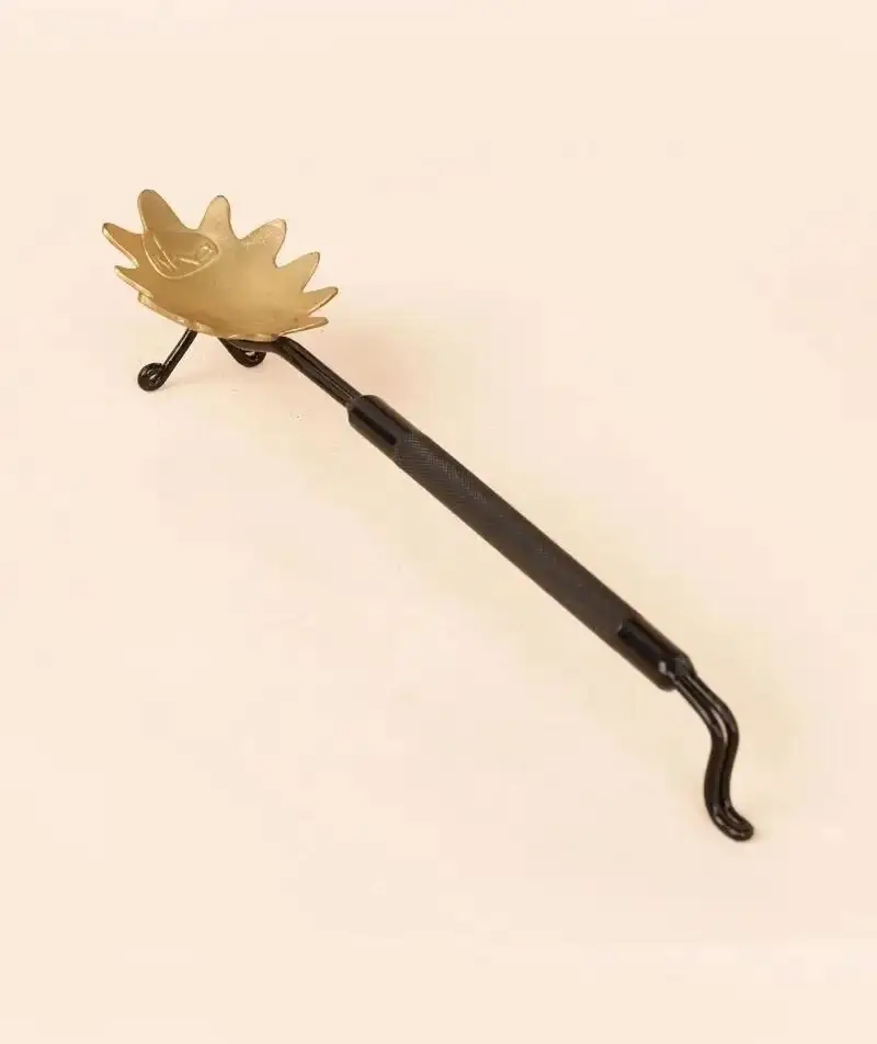 Brass aarti stand with a flower trough on a peach ground