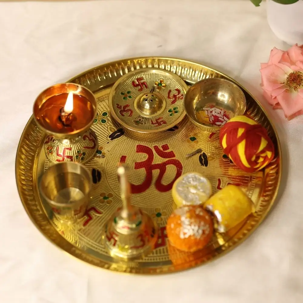 Antique gold brass pooja thaal with Om and swastika motifs, bowls and a lamp
