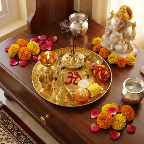 The thaal set on a wooden mandir with marigolds and an idol