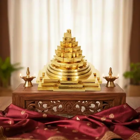 The yantra on a wooden shelf with two small lamps