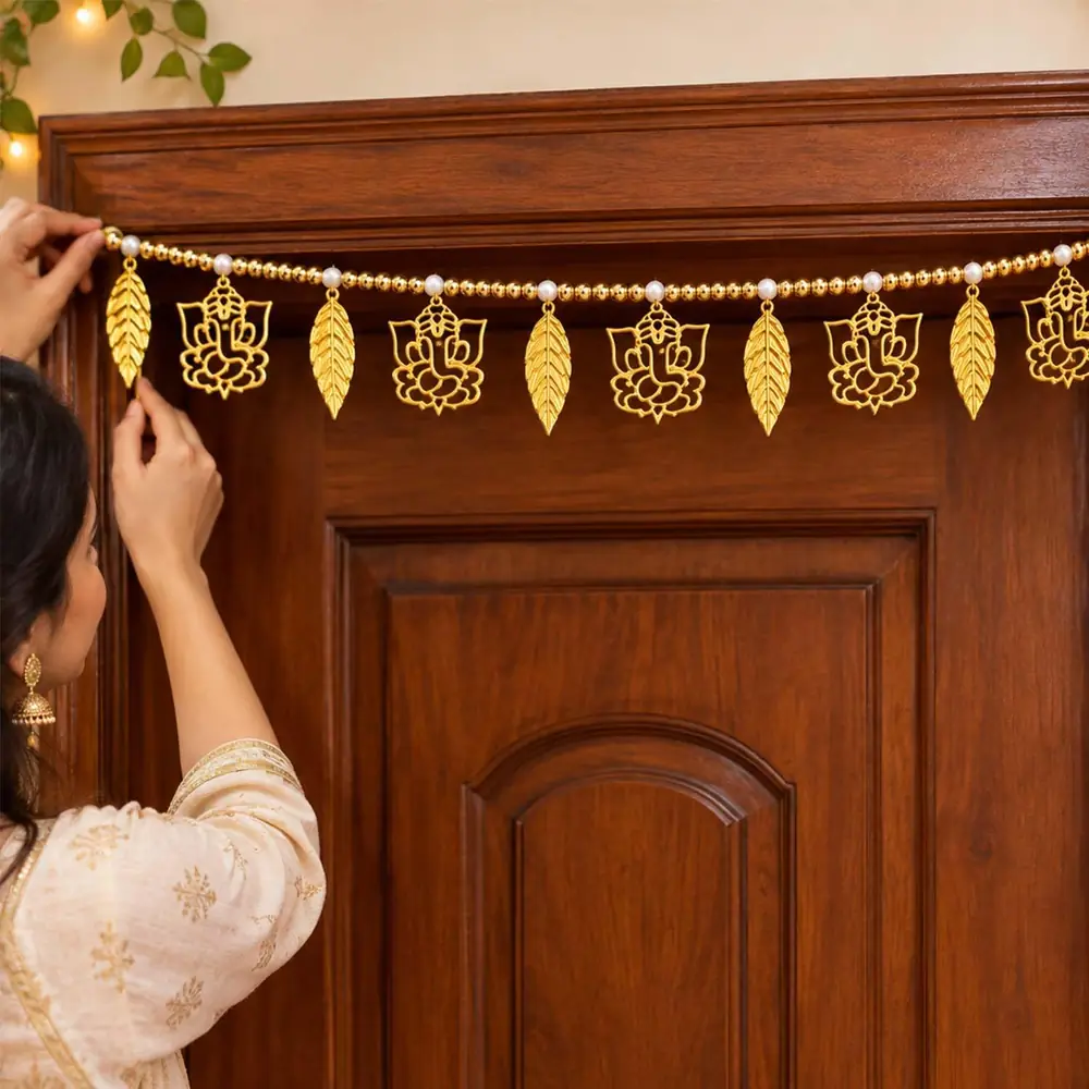 A woman hanging the toran over a door