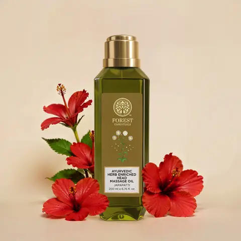 Bottle beside red hibiscus flowers