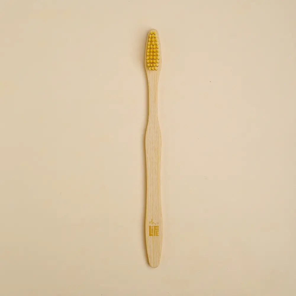 Bamboo toothbrush resting on its kraft paper sleeve