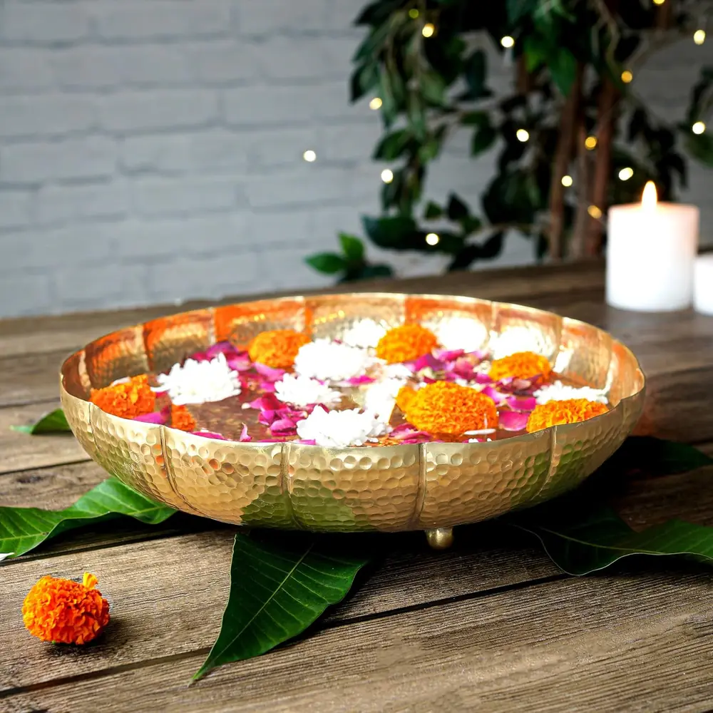 Roses and jasmine floating in the lotus urli on a green leaf