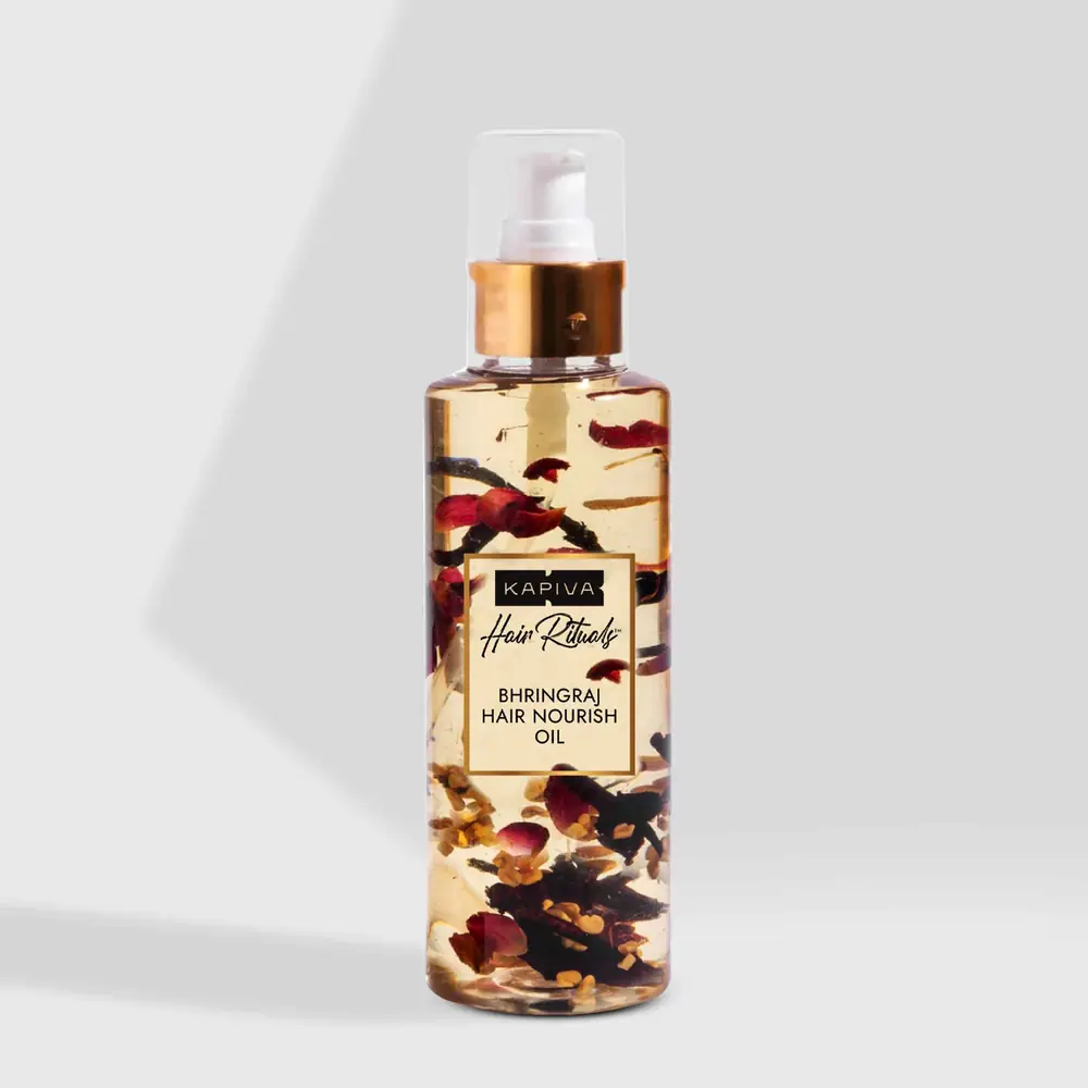 Bottle of Bhringraj hair oil with herbs visible inside