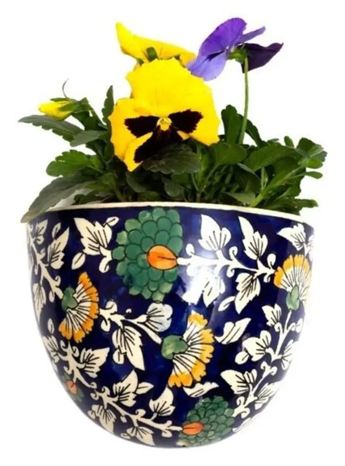 Blue ceramic half-round planter holding pansies