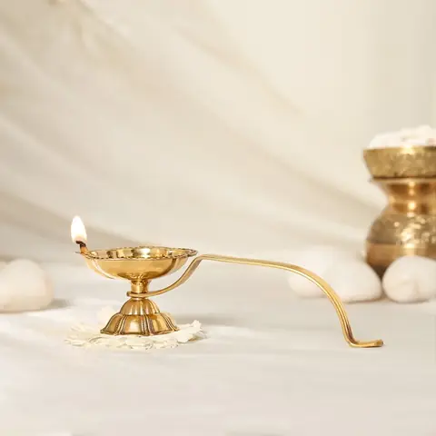 Brass aarti diya with its long handle, side view