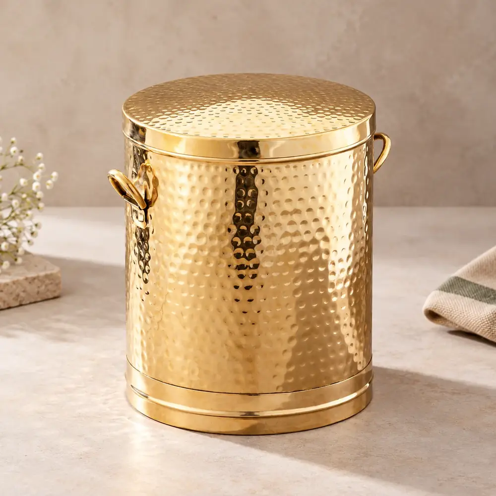 Hammered brass atta daani with its lid on a kitchen counter