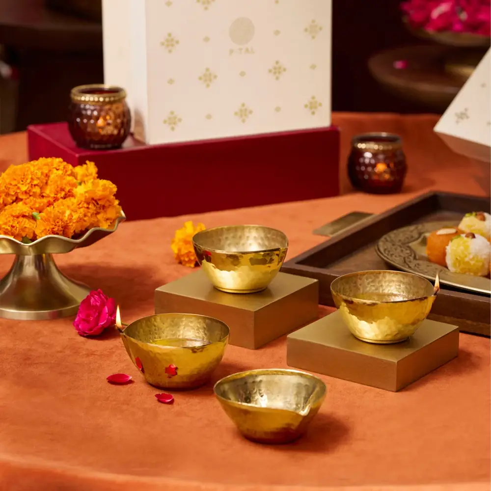 Set of brass diyas with marigolds and puja items