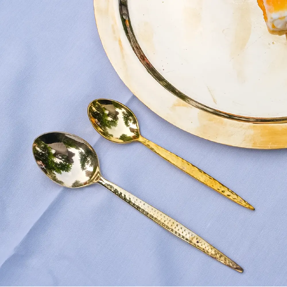 A hammered brass spoon on a blue cloth