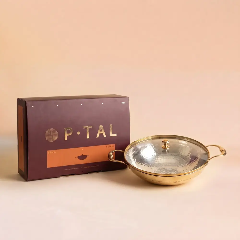 Brass kadhai with a glass lid beside its box