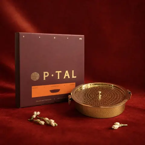 Brass lagaan beside a dark gift box on red cloth