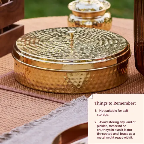 Spice box with a hammered lid on a table with a small brass jar