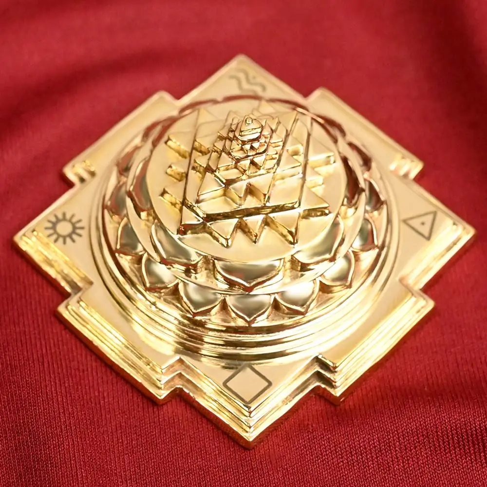 Brass Meru Shree Yantra from above at an angle on maroon cloth