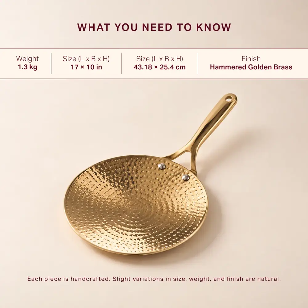 Hammered brass roti tawa with a long handle on a cream ground, with a strip of details across the top