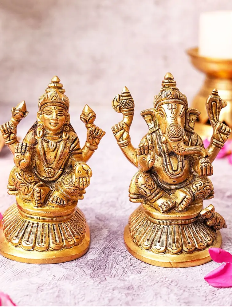 Brass Lakshmi and Ganesha seated side by side with flowers