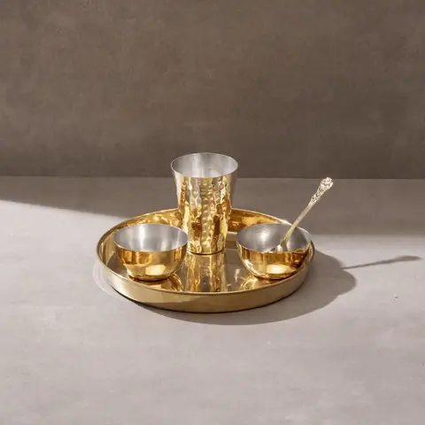 One brass thaali with bowls, a glass and a spoon