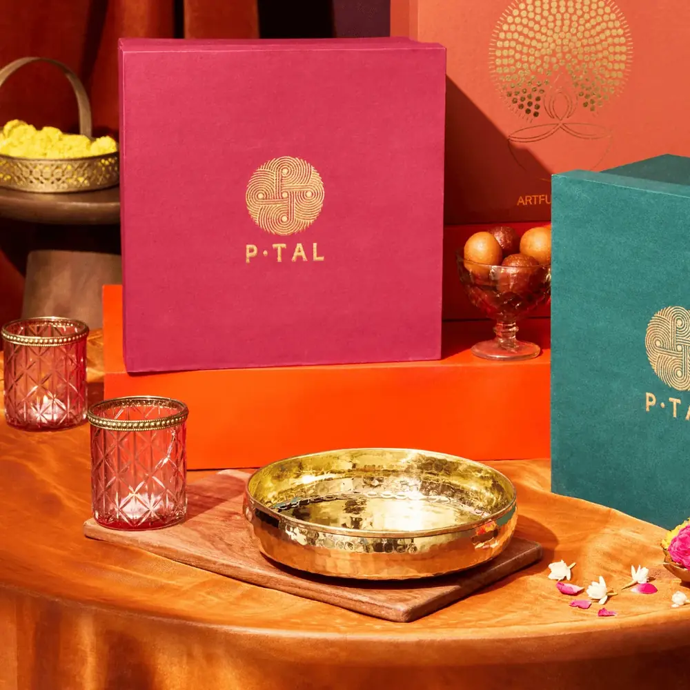 The bowl beside diyas and a gift box in a festive setting