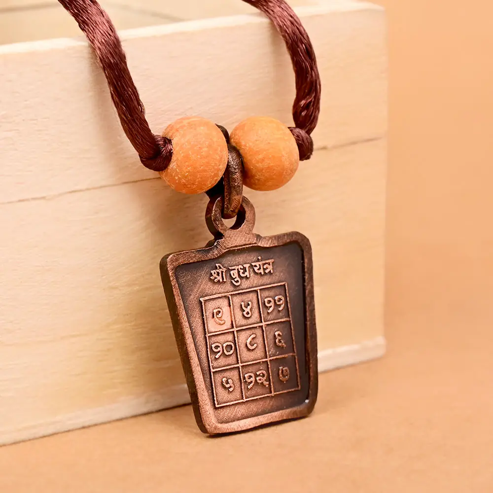 The yantra side on a brown cord with two beads