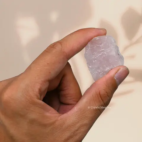A small rose quartz stone held between finger and thumb