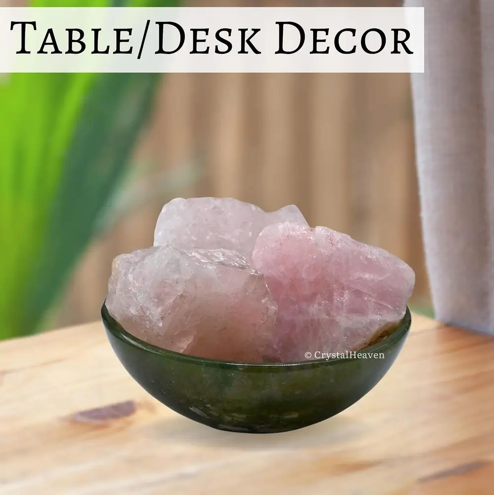 Rough rose quartz pieces in a dark bowl on a table