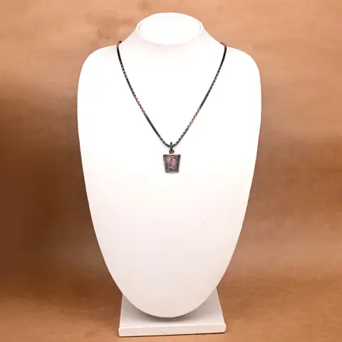 The locket on a jewellery bust, showing how small it is