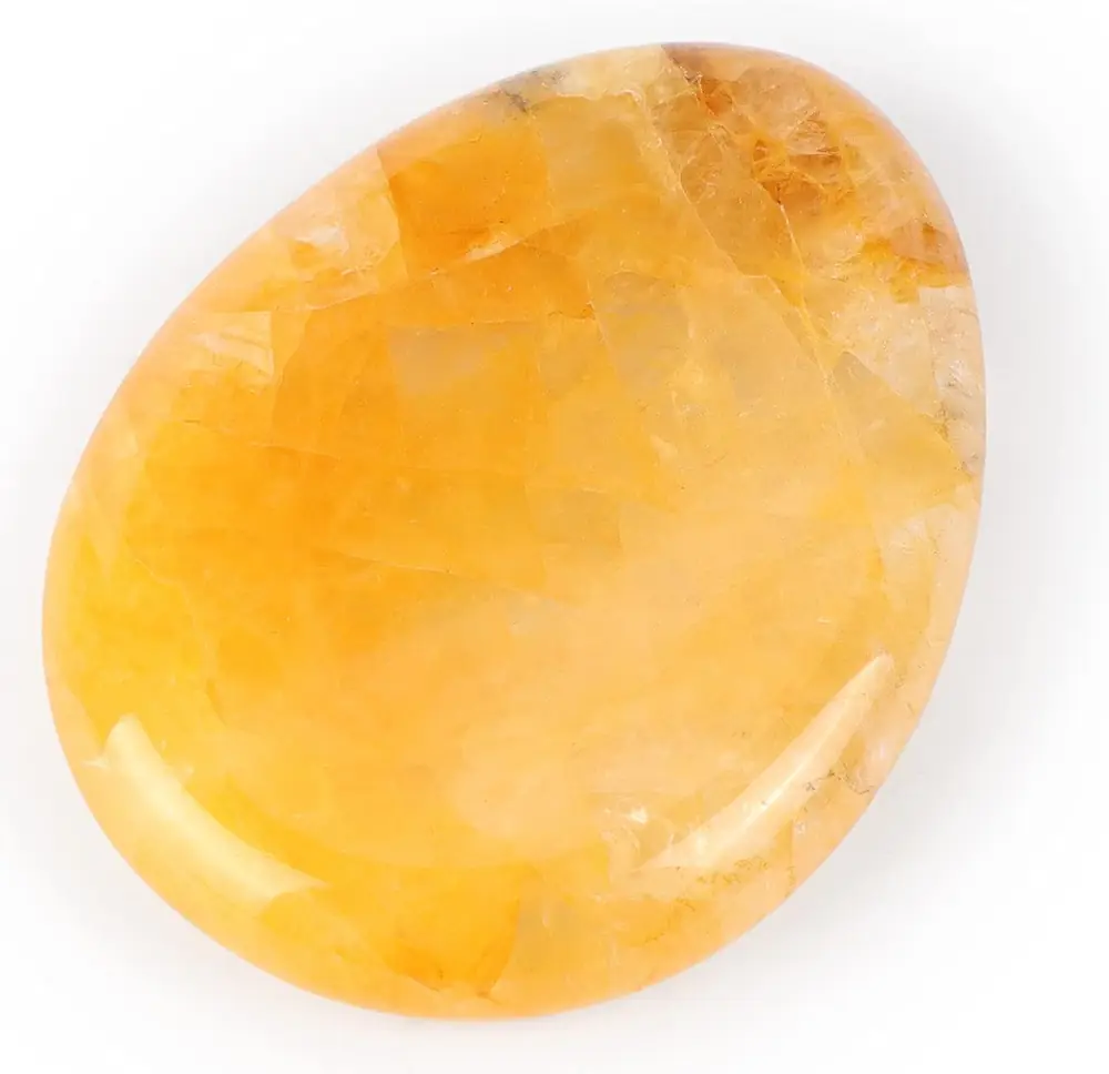 A yellow-orange citrine palm stone on a white ground