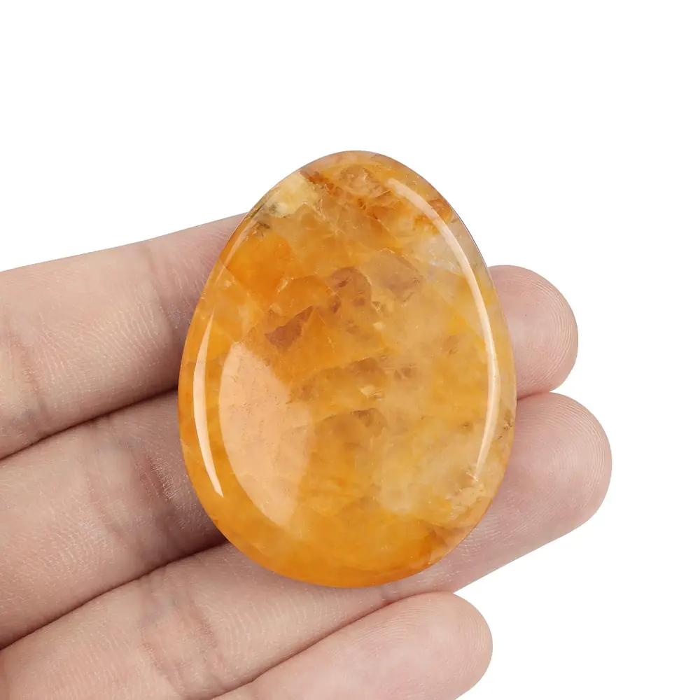 A hand holding the citrine stone