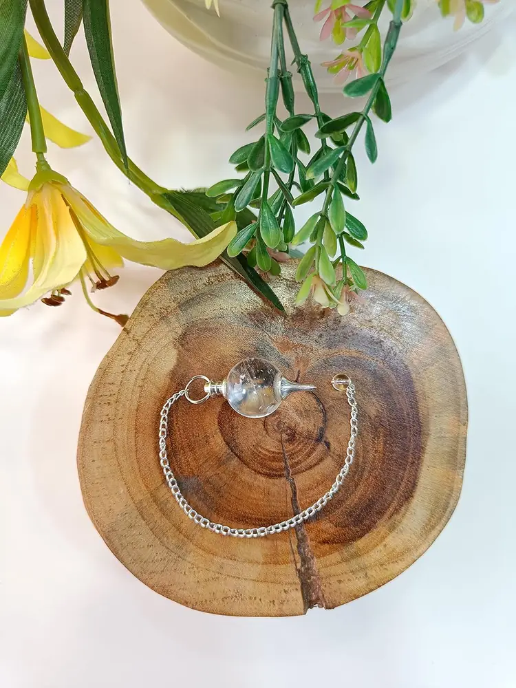 The pendulum resting on a slice of wood with leaves