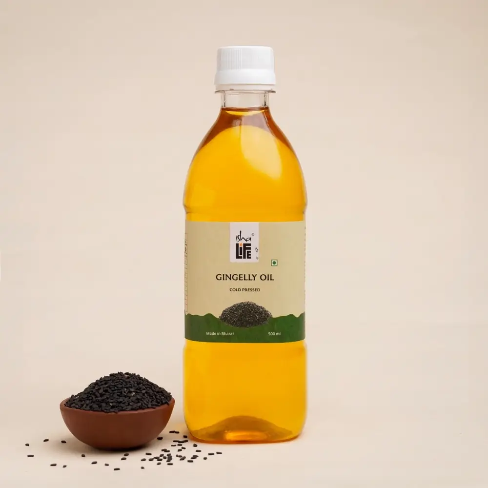 Gingelly oil bottle with golden oil and a bowl of sesame seeds