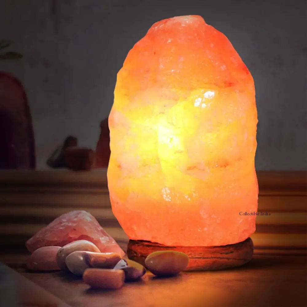 A lit salt lamp on a dark wooden base