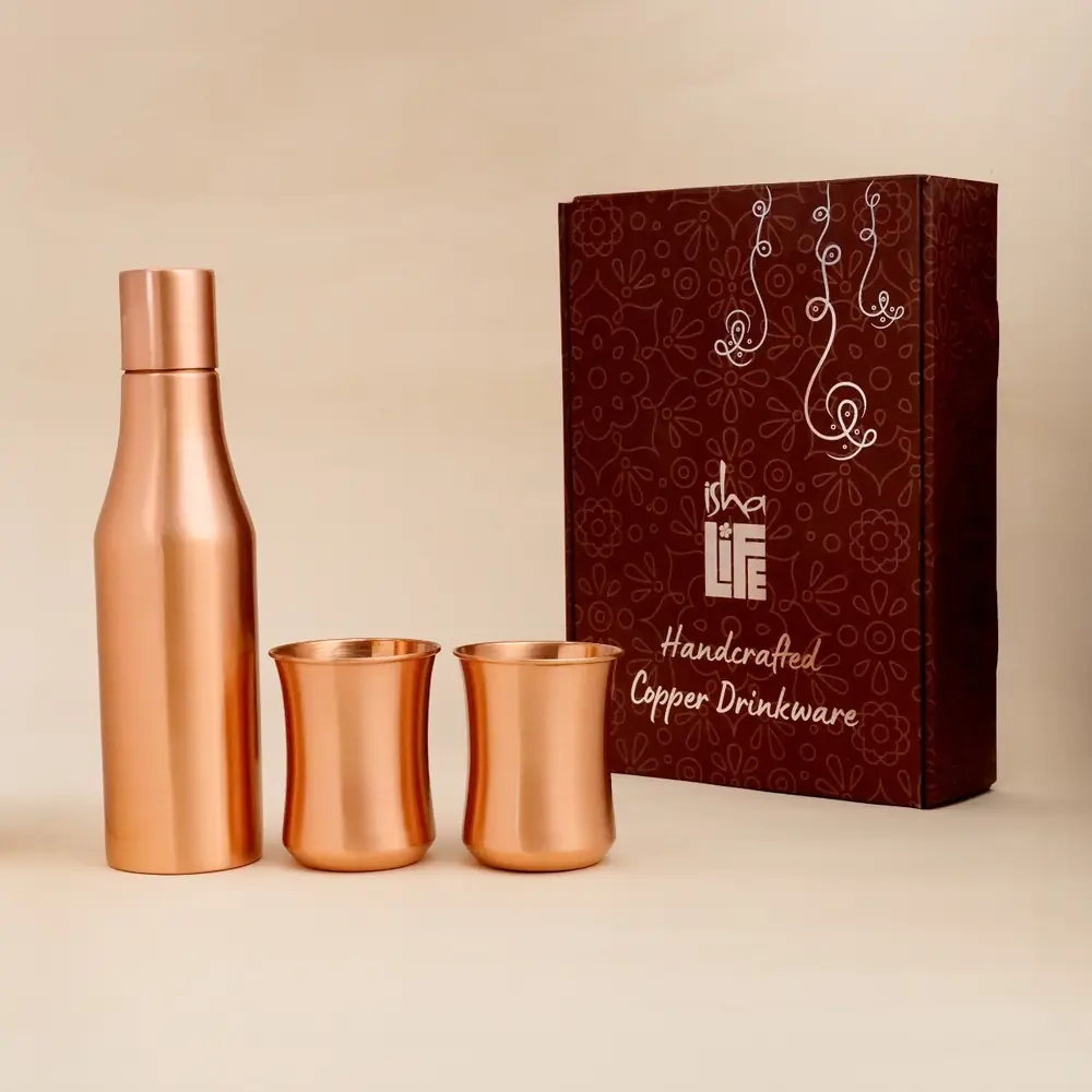 Copper bottle and two glasses beside a maroon gift box
