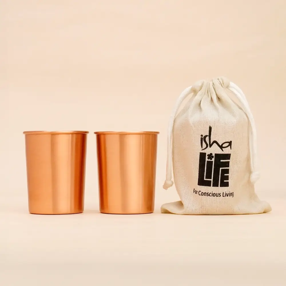 Two copper glasses beside a cream drawstring bag