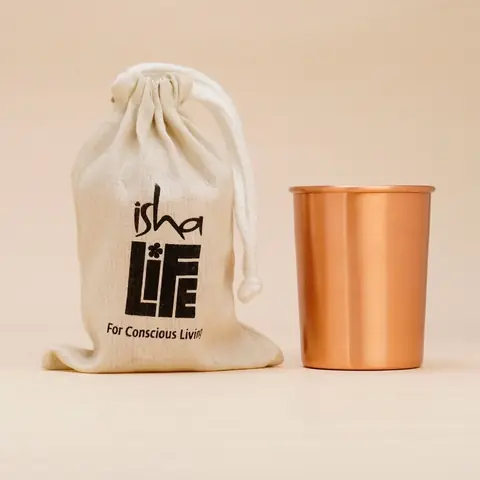 A glass beside the cloth bag with the logo