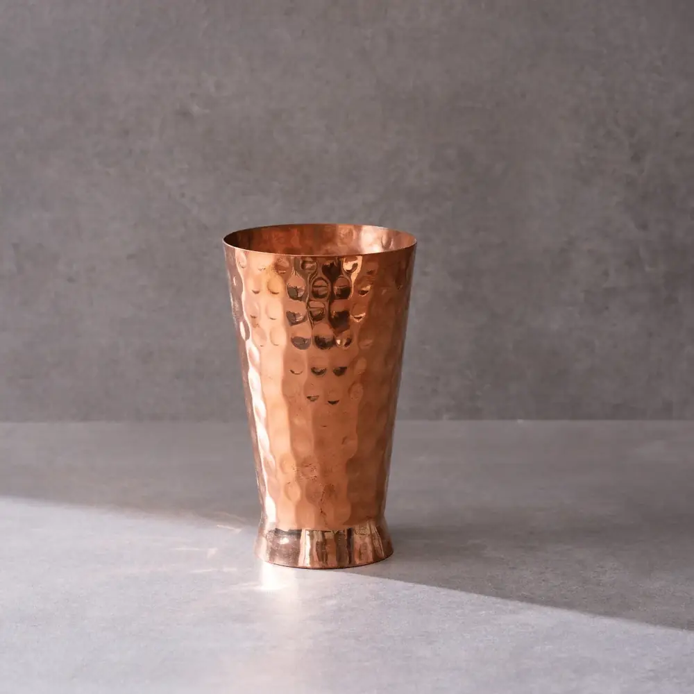Hammered copper glass on a grey ground
