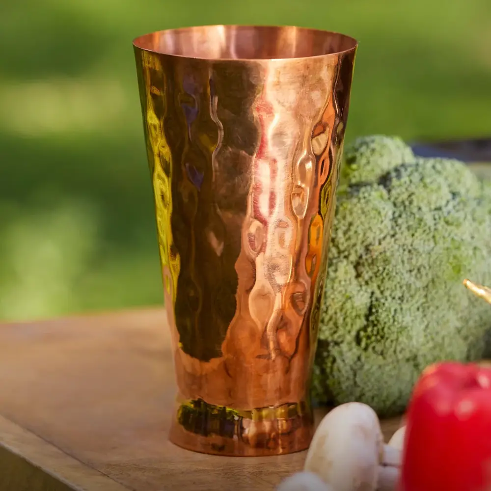 The glass on a green garden background with vegetables