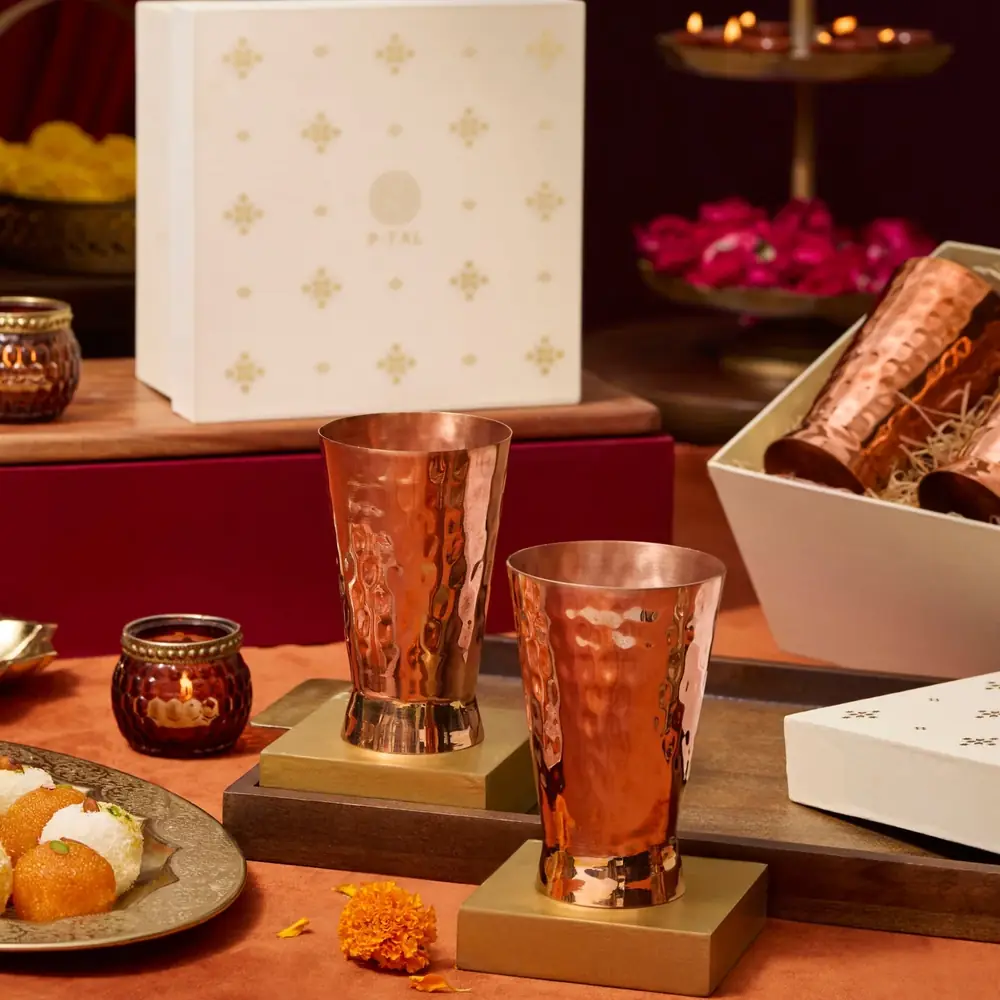 The glass in a styled scene beside a gift box and sweets