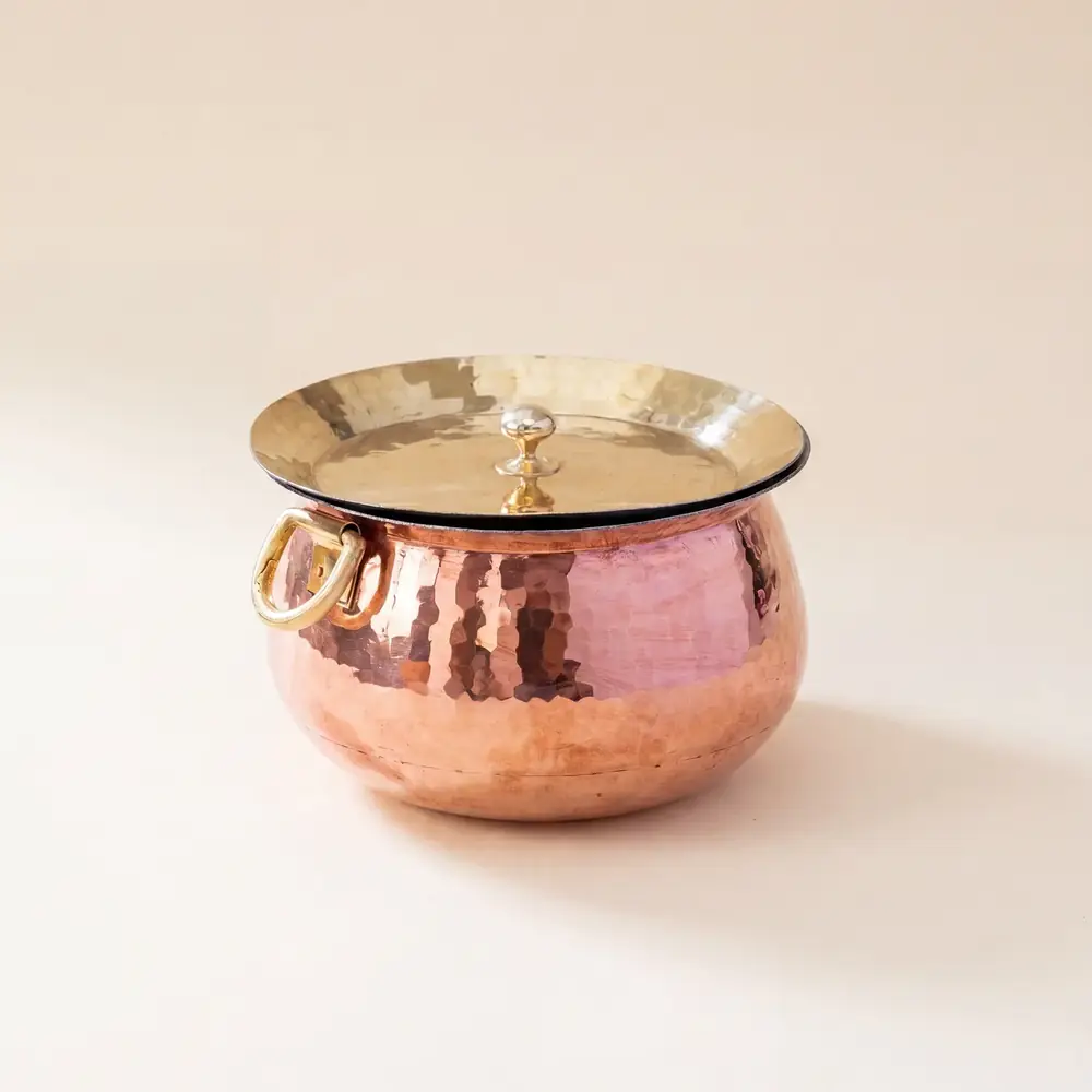 Copper Madurai handi with a lid on a pale ground