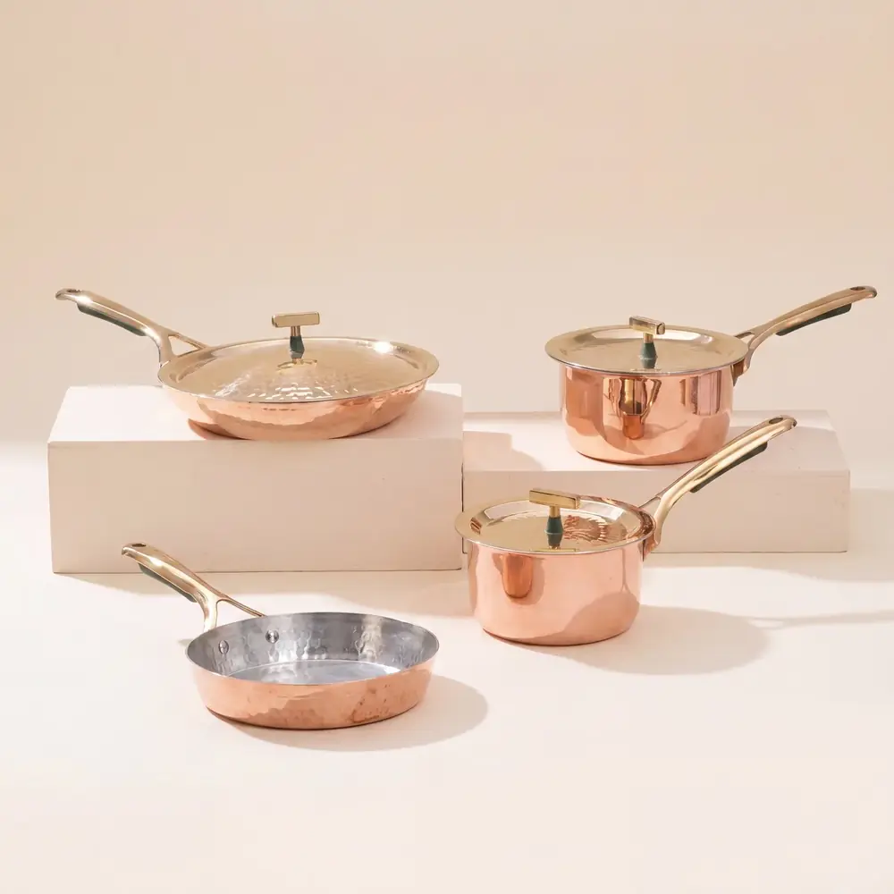 Copper pots and pans set arranged on steps with lids